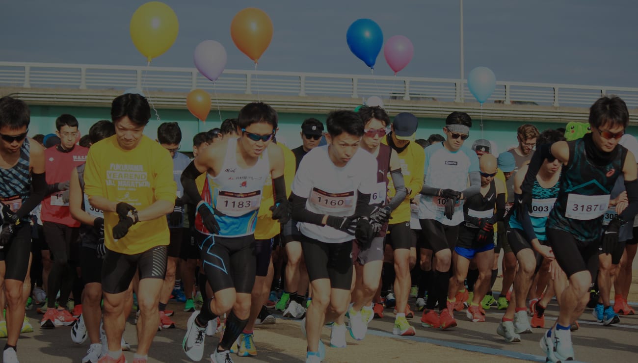 Runners at the start line of a previous Fukuyama Year End Marathon, balloons overhead